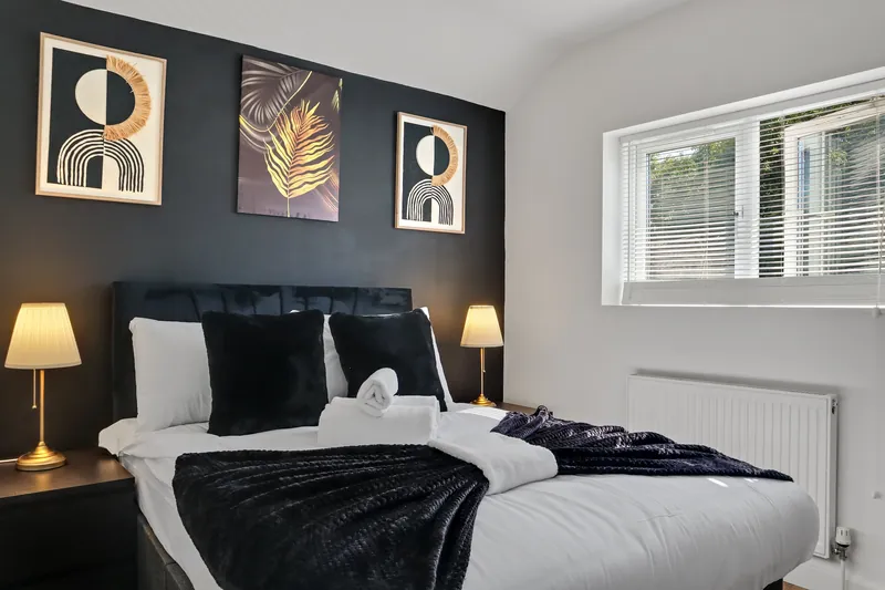 Bedroom with dark feature wall and gold artwork
