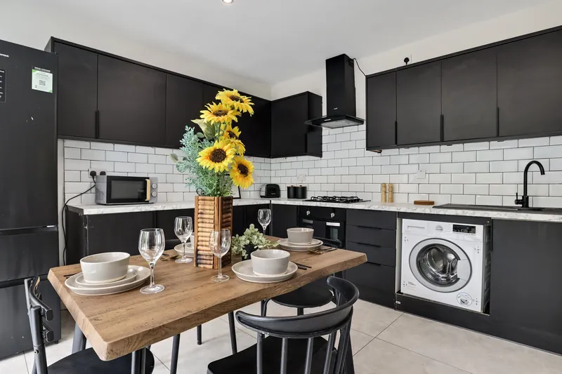 Black kitchen with dining table and sunflowers